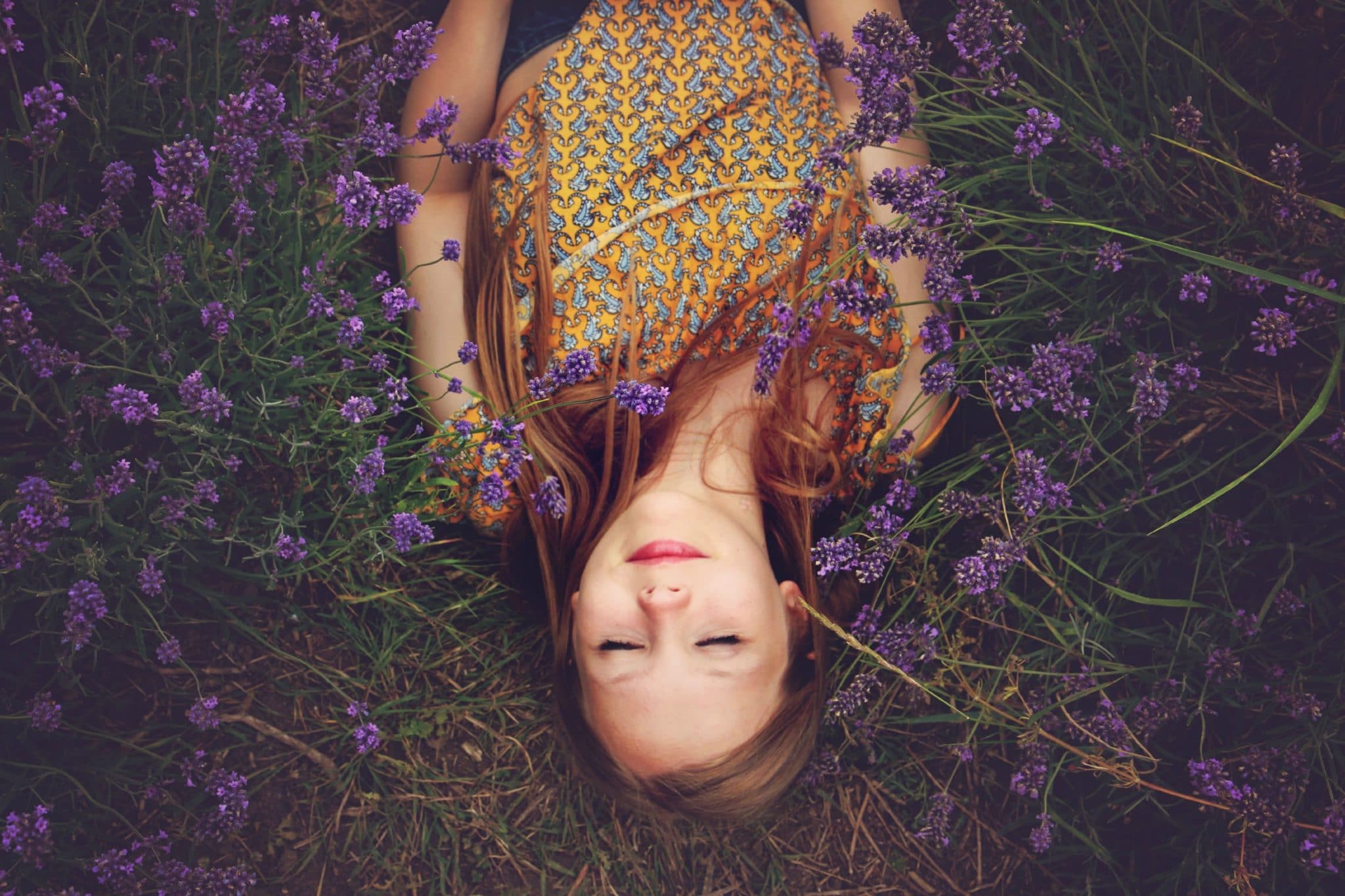 child sleeping in flowers outside