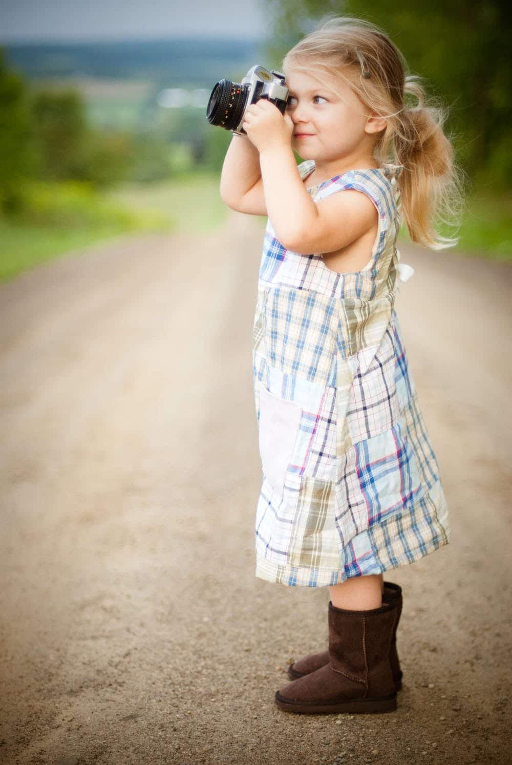 child taking photo outdoors
