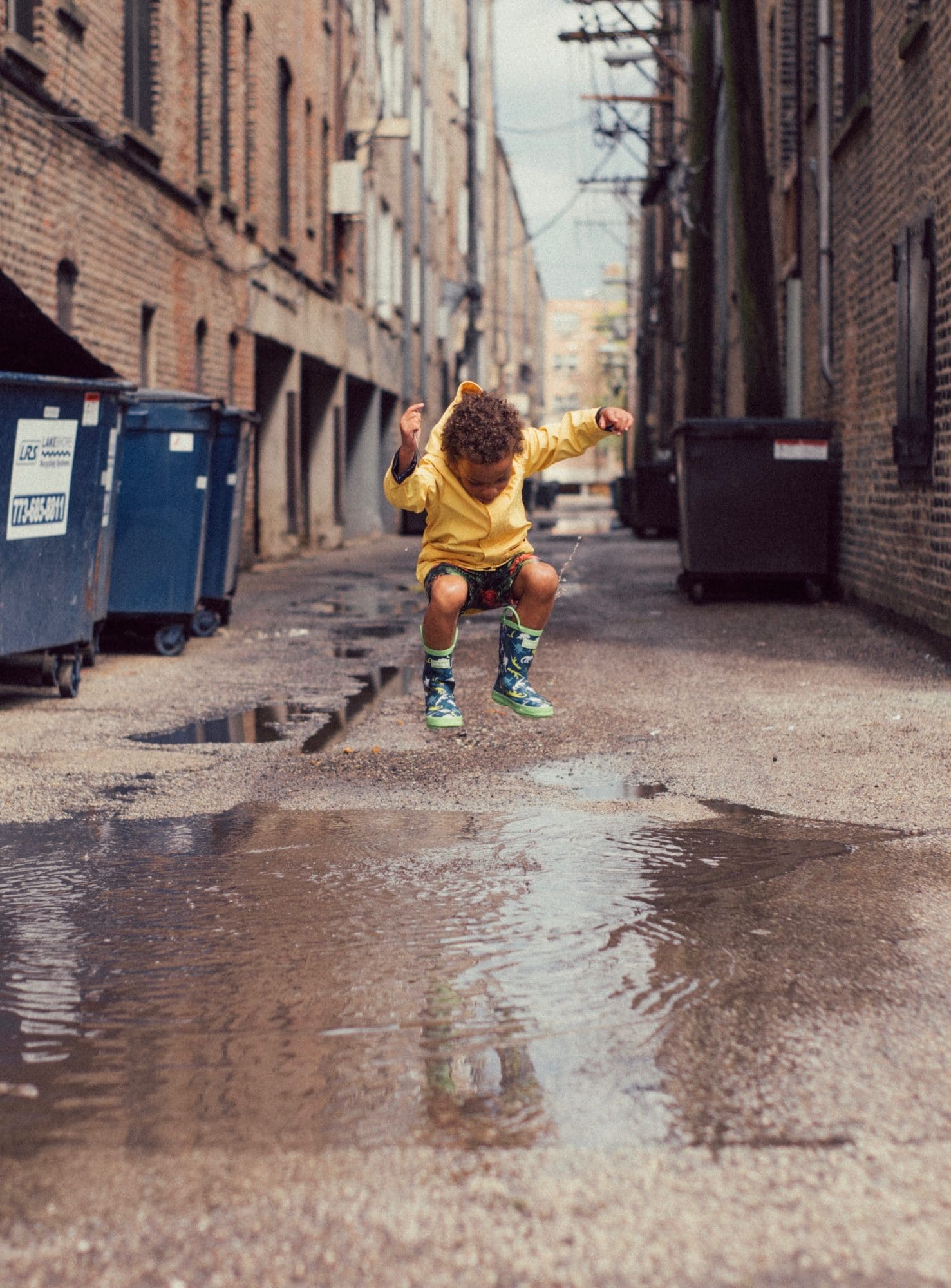 child splashing in puddle
