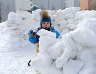 child building snow fort